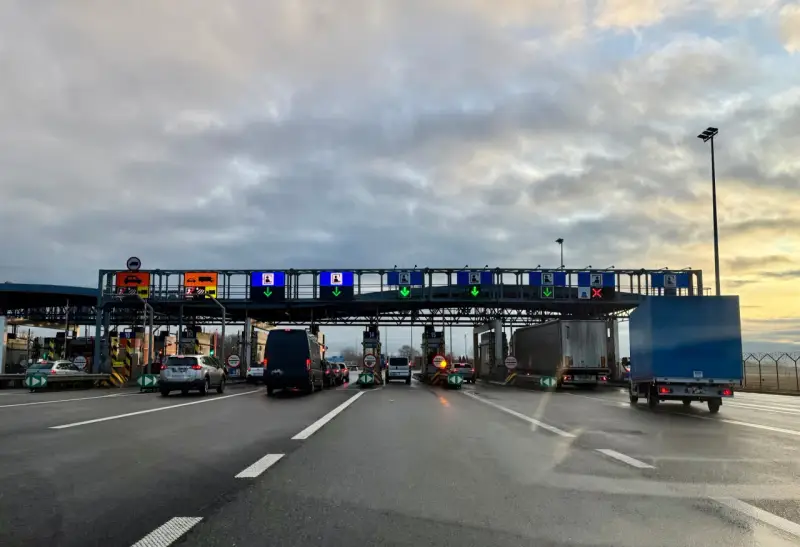 Kolejka samochodów na autostradzie A4 przed punktem poboru opłat. Zielone strzałki wskazują otwarte bramki.