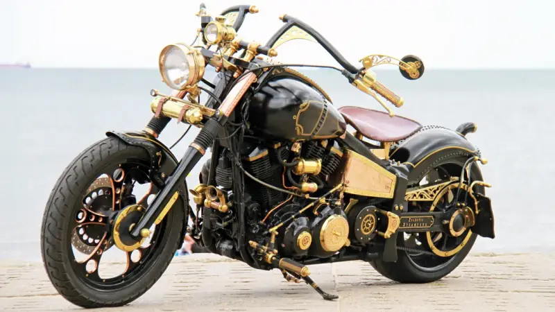 Niestandardowy Yamaha Wild Star 1600 w stylu steampunk, z bogactwem złotych detali i mosiężnych elementów, prezentuje się imponująco nad morzem.