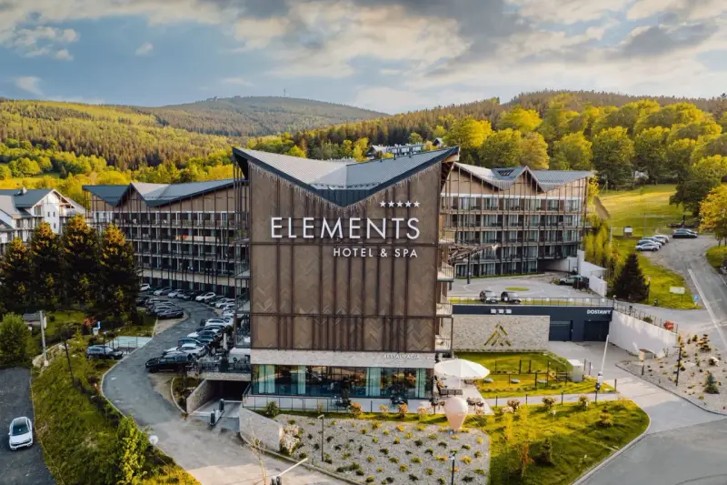 Nowoczesny hotel przy stoku narciarskim w Polsce, Elements Hotel & Spa, otoczony zielenią i górami. Idealne miejsce na zimowy wypoczynek.