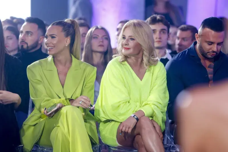 Dwie kobiety w stylizacjach w kolorze limonkowym siedzą w pierwszym rzędzie.