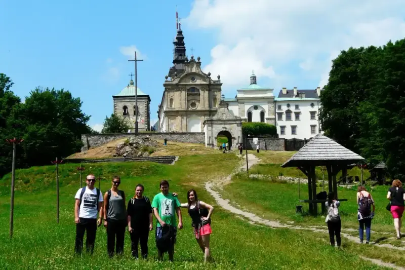 Grupa turystów na tle klasztoru na Świętym Krzyżu, miejscu pełnym łysa góra legend.