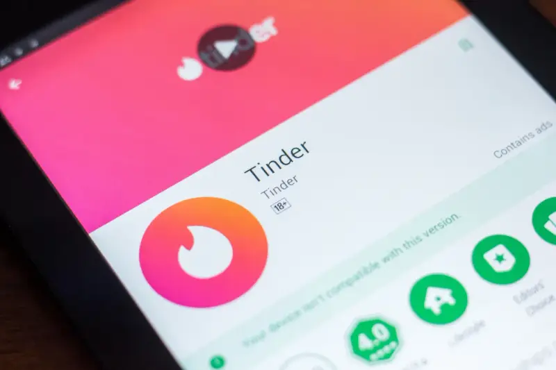 Ekran tabletu z aplikacją Tinder, gdzie szukasz idealnych **tinder pary**. Widoczne logo i nazwa aplikacji.