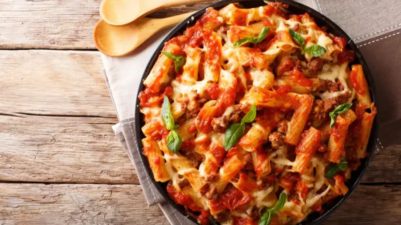 Pyszne danie z makaronem rigatoni, sosem pomidorowym i mięsem mielonym, zapieczone z serem. Idealne co na obiad z mięsa mielonego.