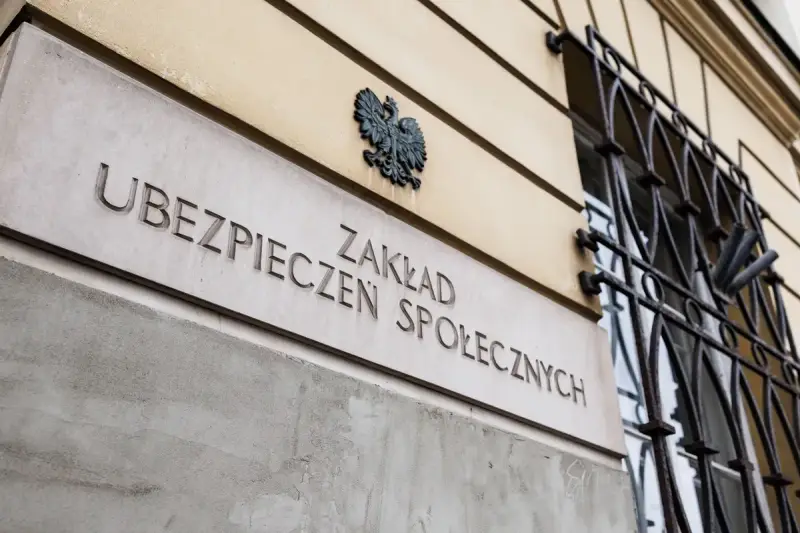 Tablica z napisem "Zakład Ubezpieczeń Społecznych" i godłem Polski.