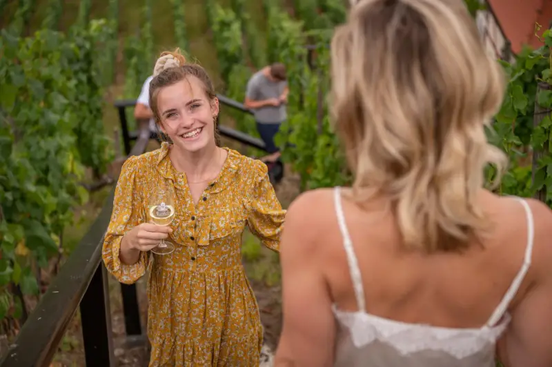 Lachende junge Frau mit Weinglas im Weinberg an der Saale-Unstrut.