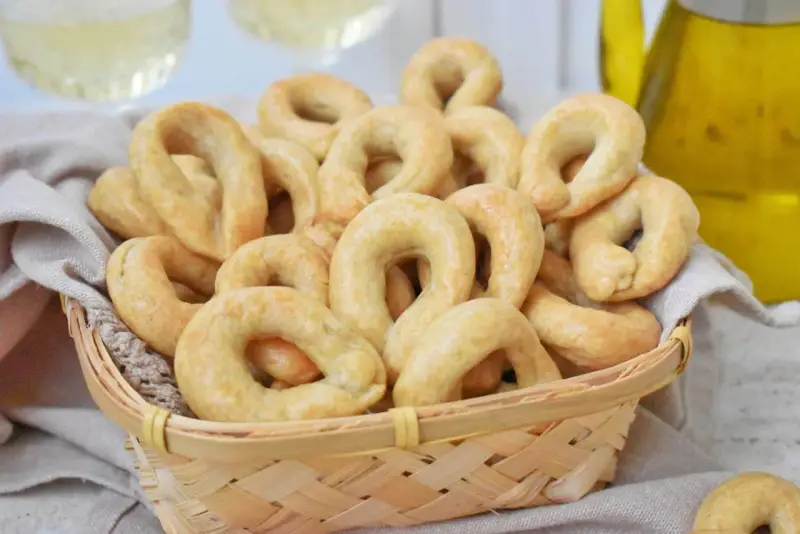 Koszyk pełen chrupiących taralli, idealnych do chrupania. Ten przepis na taralli to sekret włoskiej przekąski.