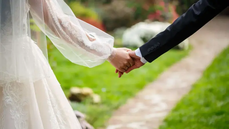 Brautpaar hält Händchen, ein Zeichen für ihren Sonderurlaub zur Hochzeit.