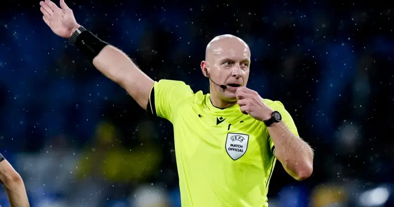 Sędzia piłkarski w żółtej koszulce z naszywką UEFA, dmucha w gwizdek. Zastanawiasz się, ile zarabia sędzia piłkarski?