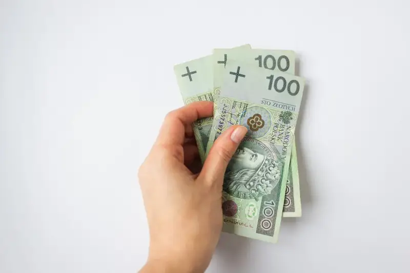 Dłoń trzyma banknoty 100 zł. To 300 zł, wystarczające na wiele przyjemności, nawet dla osoby w każdym wieku.