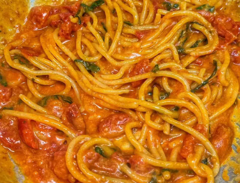 Spaghetti avvolti in un sugo cremoso di pomodoro e basilico, un invitante piatto di pasta allo scarpariello.