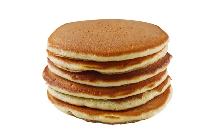 Pile de pancakes dorés faits maison avec de la farine complète, prêts à être dégustés.