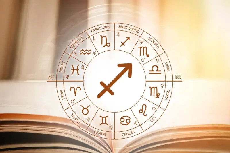 Koło zodiaku z symbolem strzelec znak zodiaku w centrum, na tle otwartej księgi.