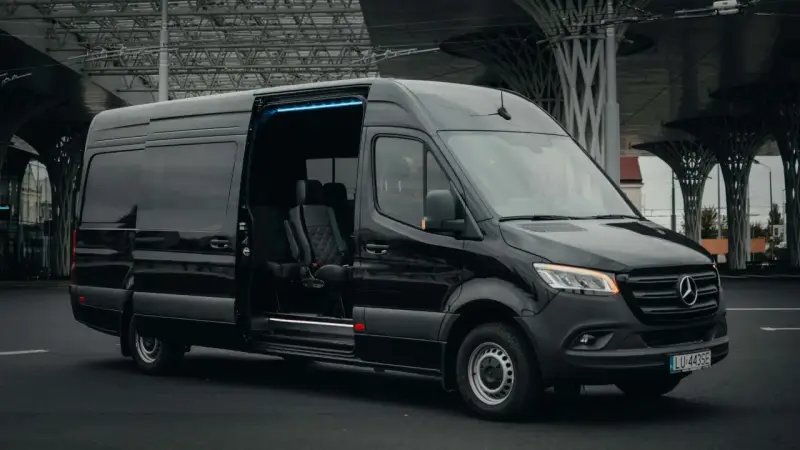Czarny Mercedes Sprinter z otwartymi drzwiami, wnętrze z wygodnymi fotelami. Zastanawiasz się, ile kosztuje bus do Francji?