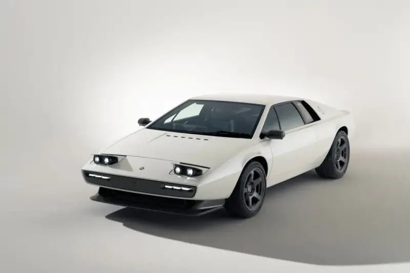Biały Lotus Esprit z lat 80. z charakterystycznymi podnoszonymi światłami i sportowymi felgami.