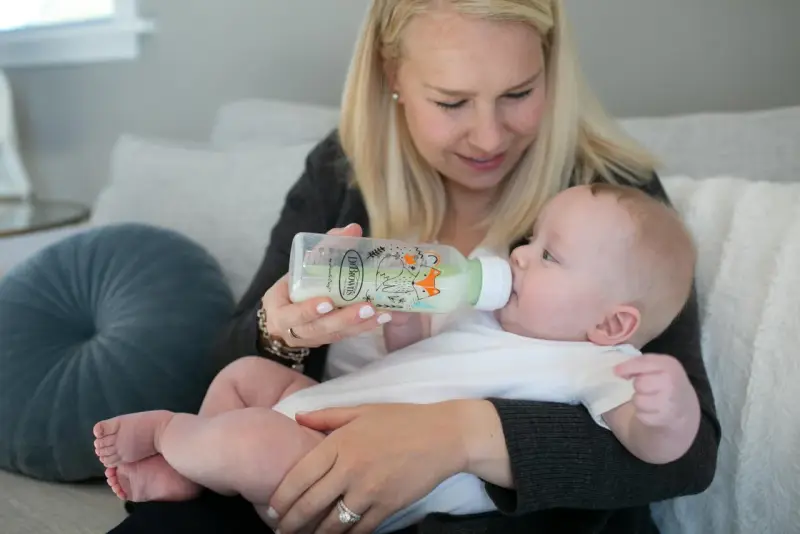 Mama karmi dziecko z butelki antykolkowej Dr Brown's z uroczym motywem lisów.