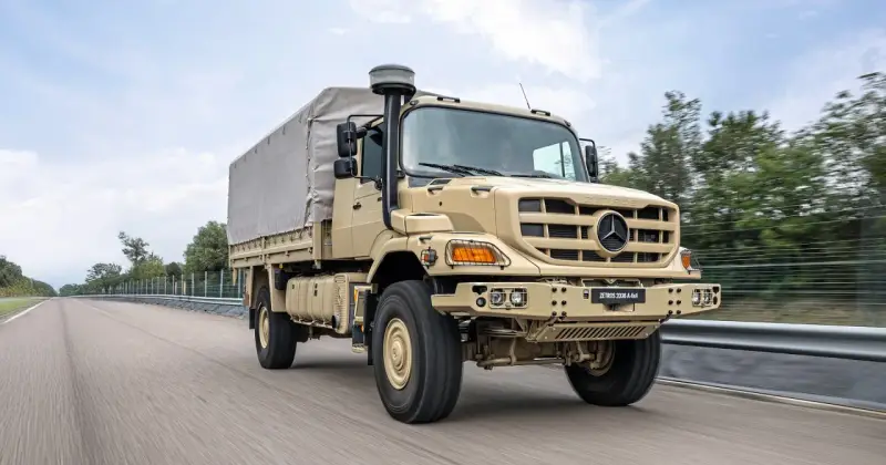 Beżowy Mercedes Zetros 2036 A 4x4 z plandeką jedzie po drodze, gotowy na każde wyzwanie.