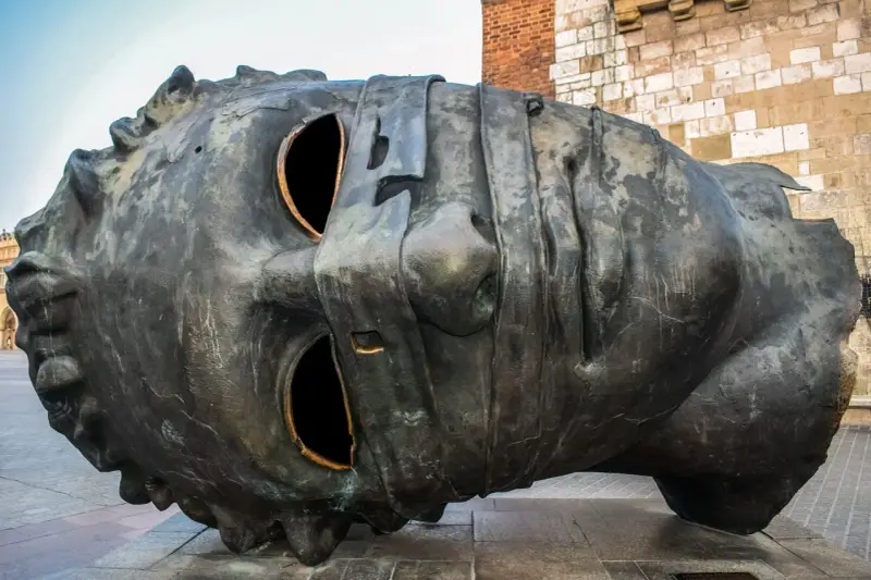 Monumentalna rzeźba głowy na Rynku Głównym w Krakowie. Jedna z wielu ciekawostek o Krakowie, która przyciąga wzrok turystów.