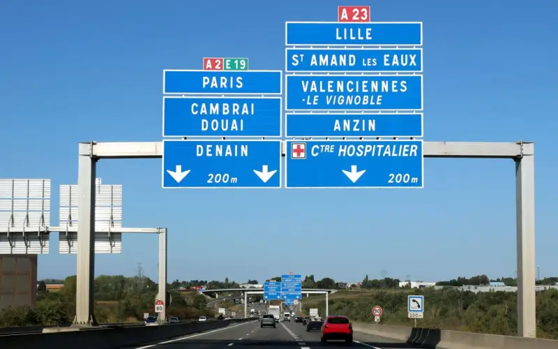 Znaki drogowe na autostradzie we Francji wskazują drogę do Lille, Paryża, Cambrai, Douai i Denain.