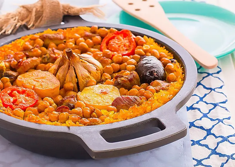 Arroz al horno valenciano con garbanzos, tomate, patata, ajo y morcilla en una paellera.
