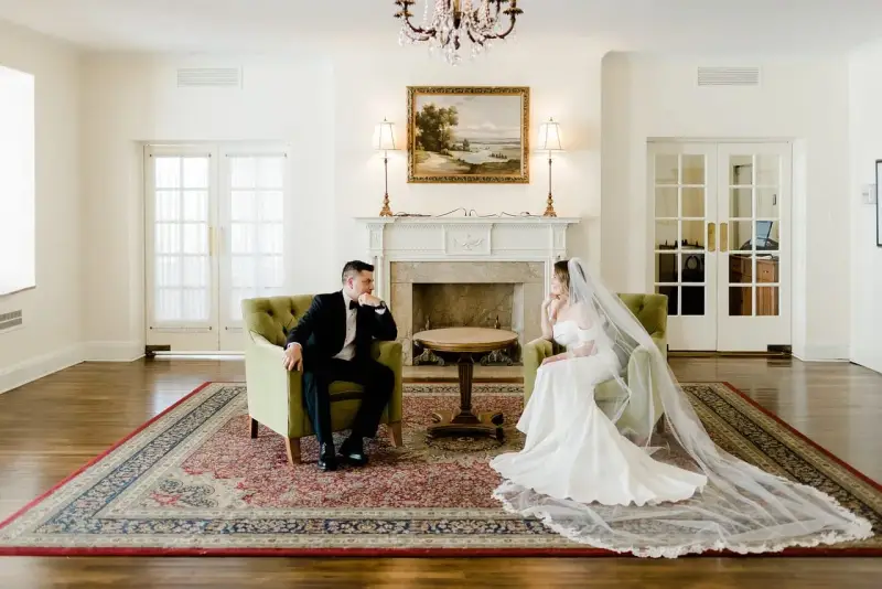 Para młoda w eleganckich strojach siedzi naprzeciwko siebie, rozmawiając o tym, co daje ślub cywilny.