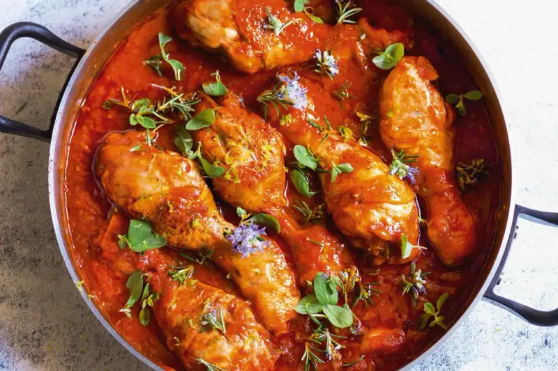 Pollo alla cacciatora succulento in padella, con erbe aromatiche fresche e scorza di limone. Un piatto rustico e saporito.