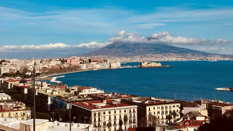 Vue panoramique de Naples avec le Vésuve en arrière-plan, un voyage inoubliable.