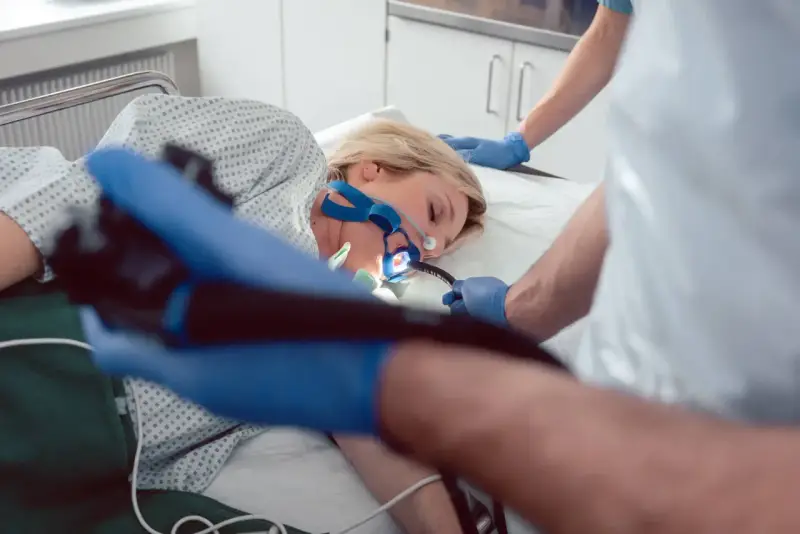 Pacjentka poddana endoskopii w celu diagnozy eozynofilowego zapalenia przełyku. Lekarz wprowadza endoskop.