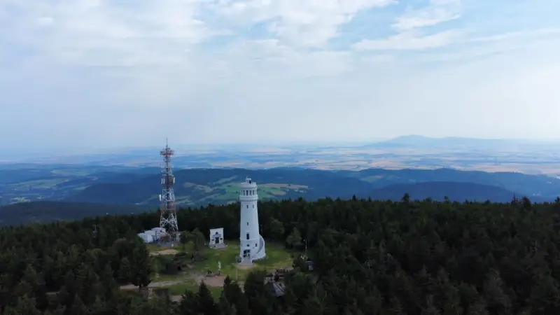 Wieża widokowa niczym wielka sowa, ile się wchodzi, góruje nad lasem. Obok maszt telekomunikacyjny.