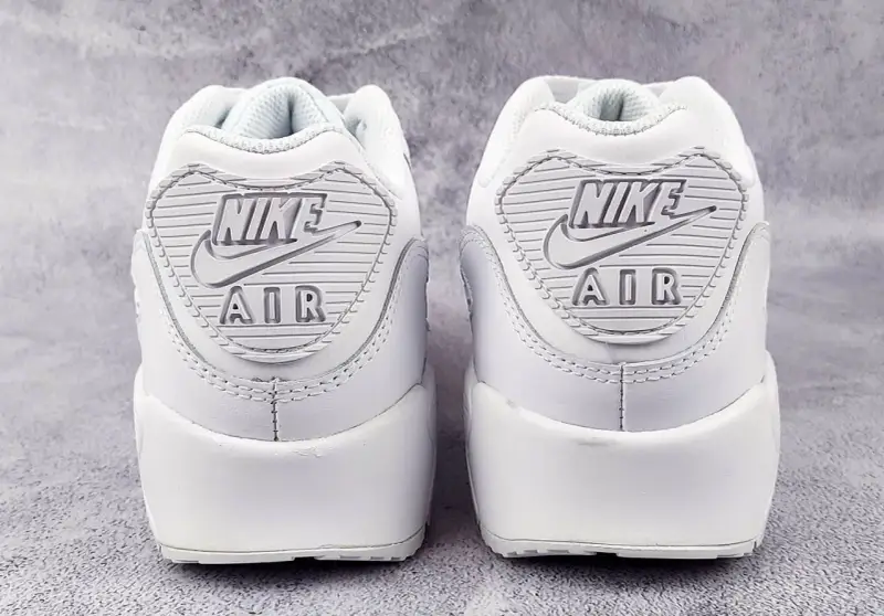 Dwa białe buty Nike Air Max 90 z widocznym logo. Sprawdź detale, by wiedzieć, jak sprawdzić czy Air Force są oryginalne.