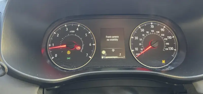 Dacia Sandero: kontrolki informują o braku widoczności kamery przedniej. Widoczne kontrolki hamulca ręcznego, ABS i ciśnienia w oponach.