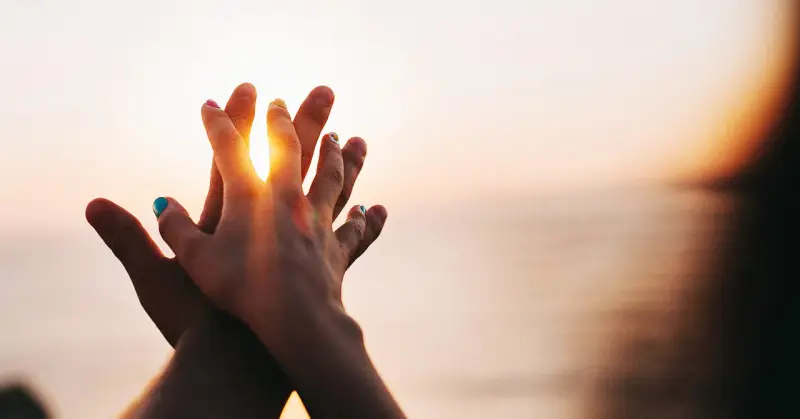 Two hands clasped at sunset, a symbol of purity and what is chastity: a deep, respectful connection.