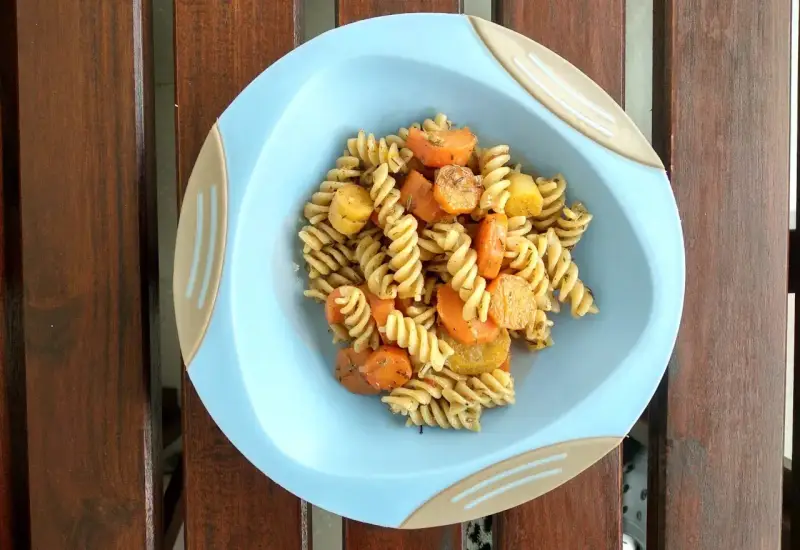 Kolacja dla niemowlaka 9 miesięcy: makaron fusilli z marchewką i ziemniakami, doprawione ziołami.