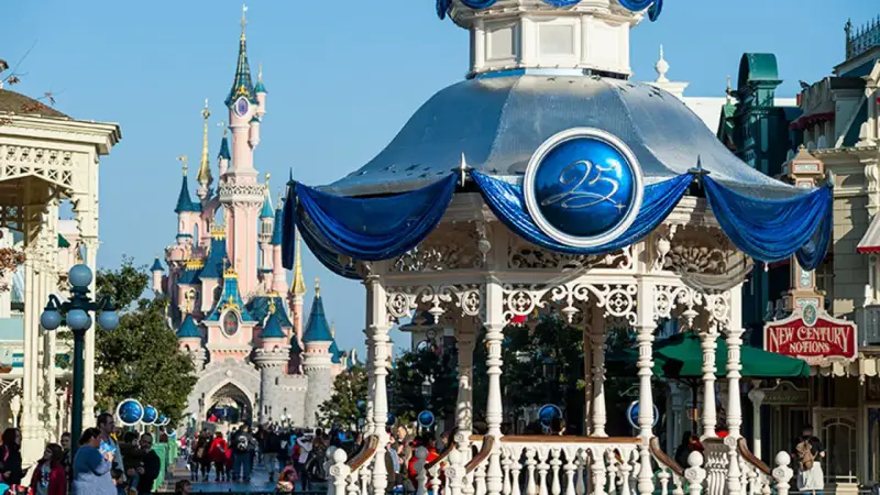 El castillo rosa de Disneyland Paris se alza majestuoso, con un quiosco decorado para celebrar el 25 aniversario.