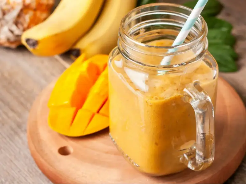 Słoneczny koktajl zamiast śniadania: gęsty, pomarańczowy napój z mango i bananów w słoiku, gotowy do wypicia.