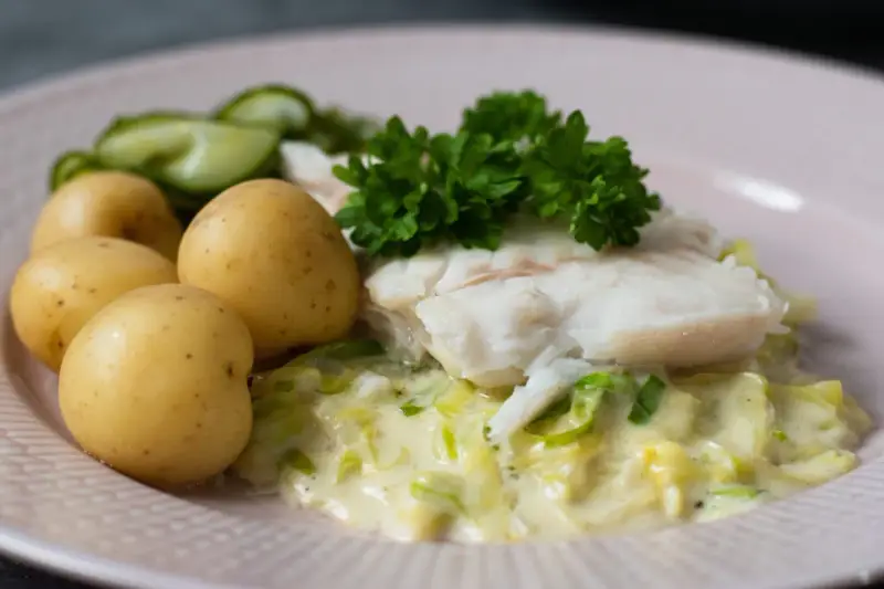 En portion stuvad spetskål med fisk, potatis och gurka. En klassisk svensk rätt som smakar ljuvligt.