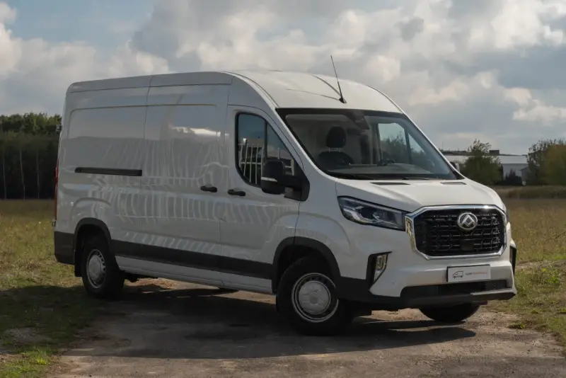 Biały Maxus Deliver 9 zaparkowany na drodze gruntowej, gotowy do transportu.