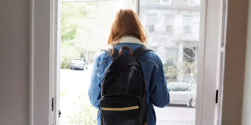 Ragazza con zaino, forse alle prese con i sintomi ADHD adulti donne, esce di casa.