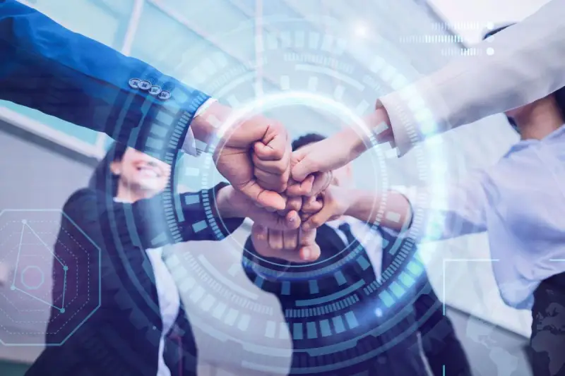 Equipo unido en un gesto de colaboración, simbolizando la transformación digital y el futuro de los negocios.