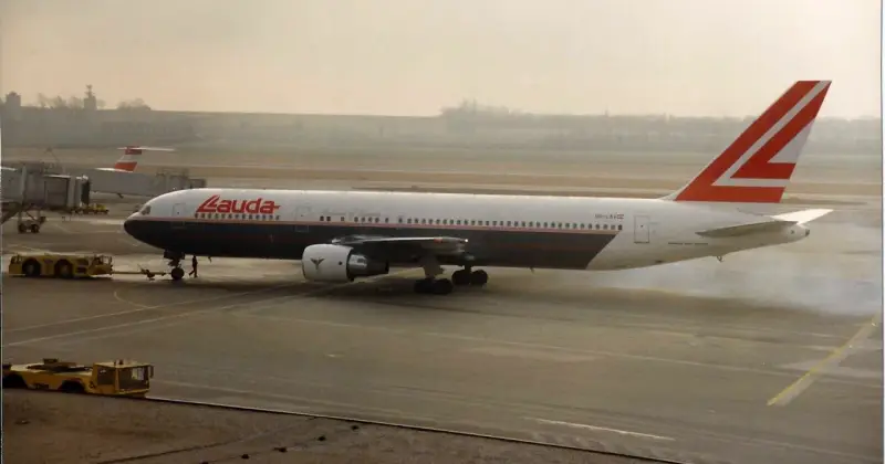 Samolot Lauda Air z charakterystycznym ogonem, kołujący po płycie lotniska.