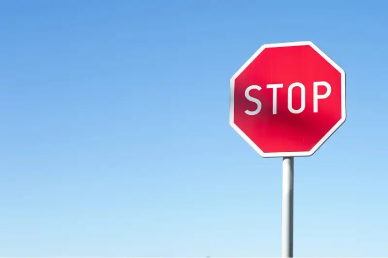 Czerwony znak STOP na tle błękitnego nieba. Uważaj, by nie dostać mandatu za stop!