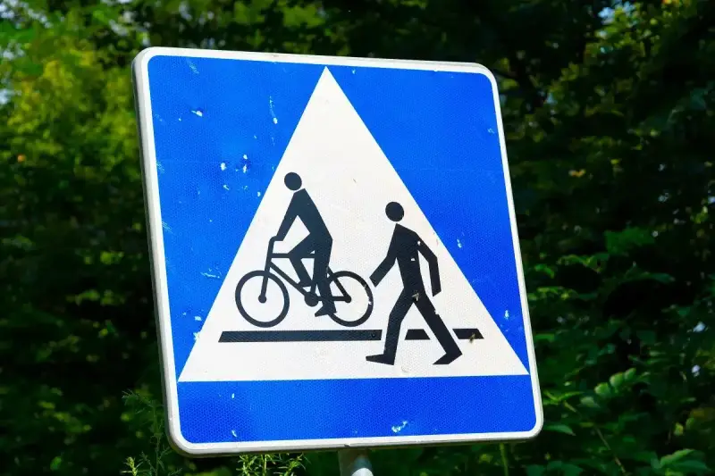 Znak ostrzegawczy: przejazd rowerowy i przejście dla pieszych. Czy rowerzysta ma pierwszeństwo na przejeździe rowerowym? Tak, ten znak informuje o tym.
