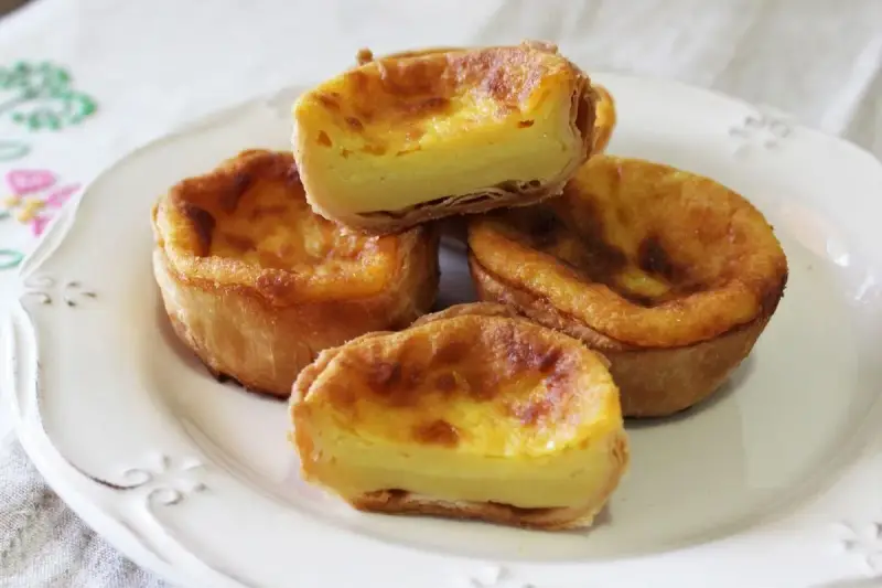 Pastel de arroz con relleno cremoso y masa hojaldrada, servido en un plato blanco.