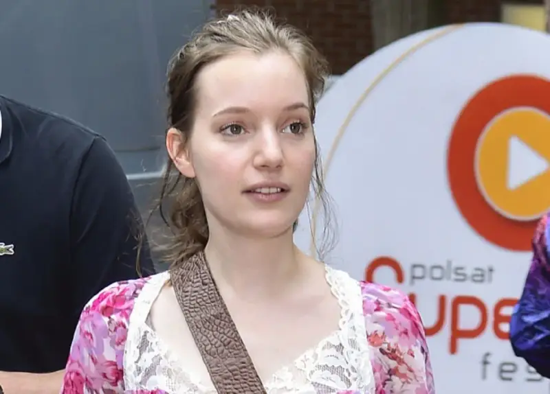 Zuzanna Jurczak, The Voice of Poland, w kwiecistej sukience z koronką, z brązowym paskiem przez ramię.