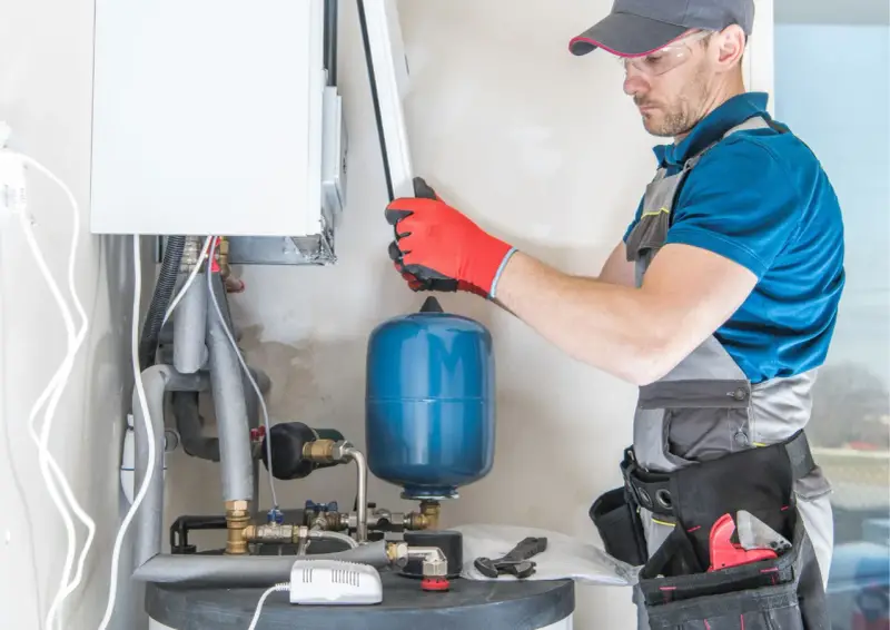 Instalator sprawdza podzespoły kotła gazowego. Zastanawiasz się, ile kosztuje piec gazowy?