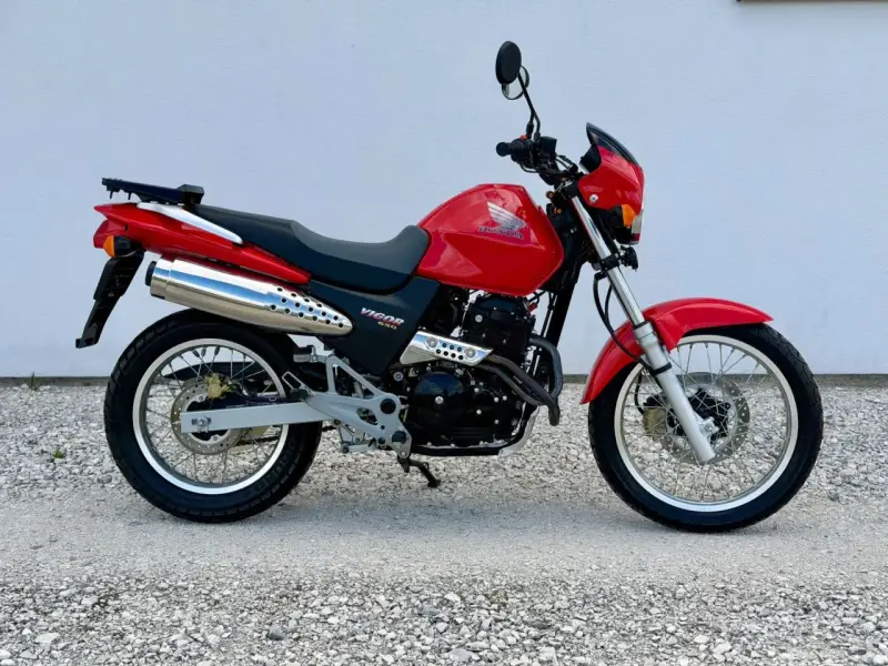 Czerwony Honda Dominator 650 Vigor. Wady i zalety tego motocykla to m.in. jego wszechstronność i prostota konstrukcji.