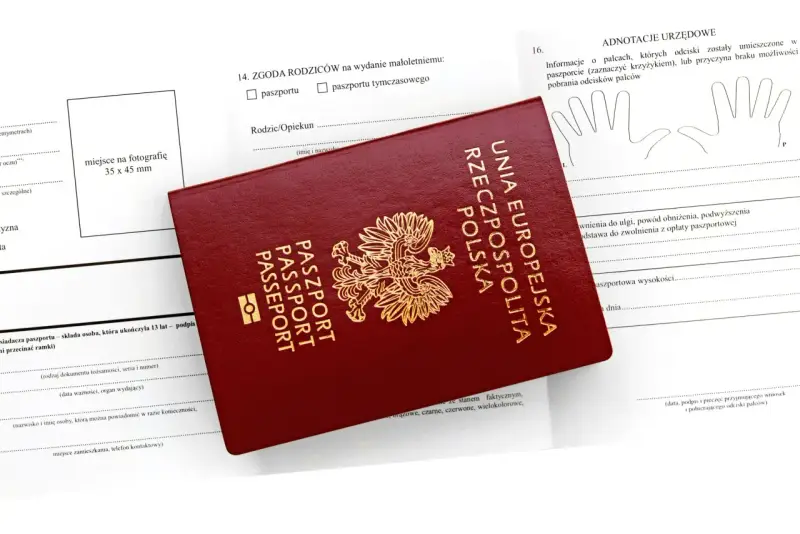 Czerwony paszport leży na formularzu. Czy wniosek o paszport można złożyć online? Formularz zawiera rubryki na dane, zgodę rodziców i odciski palców.