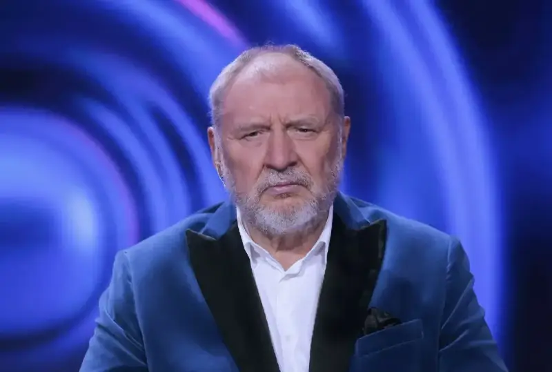 Andrzej Grabowski żyje i wygląda na zmęczonego, siedząc w niebieskiej marynarce na tle niebieskich świateł.