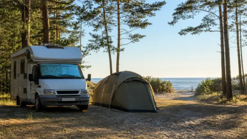 Kamper i namiot na piaszczystym terenie, wśród drzew, blisko morza. Idealne pola kempingowe w Polsce na wakacje.
