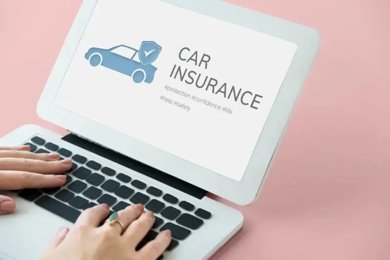 Kobieta wpisuje w laptopie frazę "ile kosztuje ubezpieczenie samochodu pierwszy raz". Na ekranie widnieje grafika samochodu z tarczą i hasło "CAR INSURANCE".