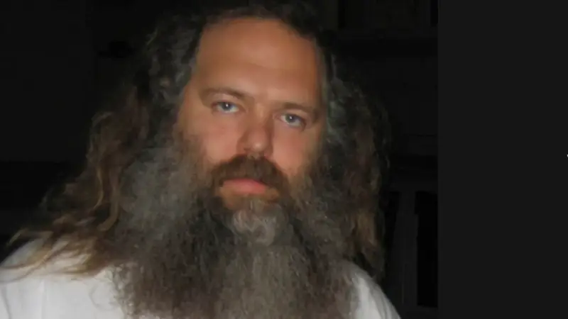 Porträt von Rick Rubin mit langem Haar und Bart, ein ikonischer Musikproduzent.